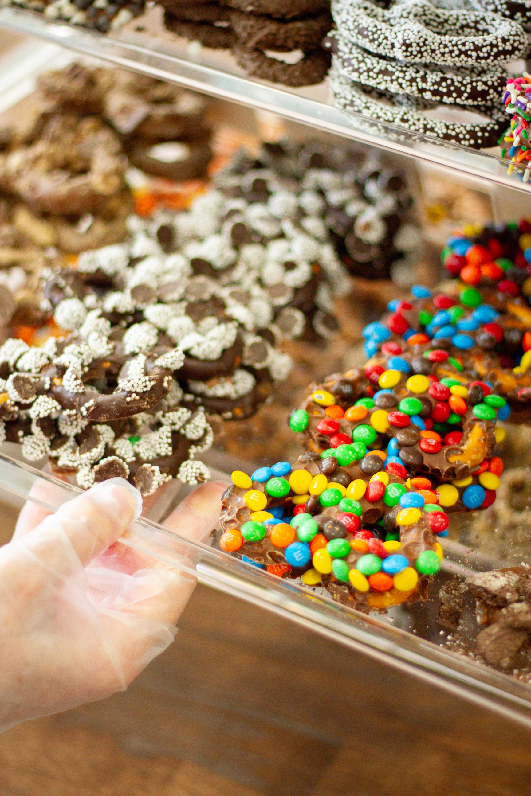 a drawer filled with cocolate covered pretzels slid out to reveal, m&m and sprinkles toppings 